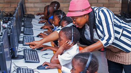 A teacher guides students through the digital landscape, showcasing South Africa's commitment to leveraging technology for inclusive learning and skill development