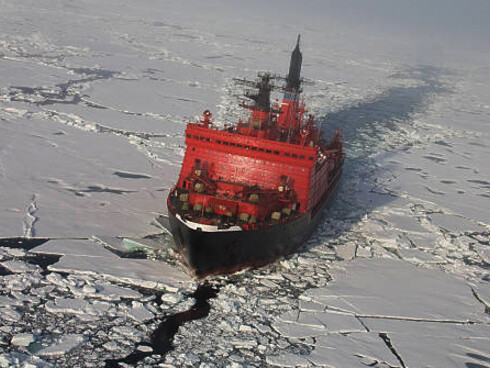A red nuclear-powered icebreaker sailing through icy waters