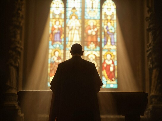 A silhouette bathed in light before the altar, symbolising hope for a church renewed by faith rather than commerce