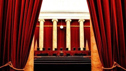 The seats of the U.S. Supreme Court, framed as a theater stage