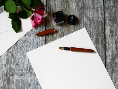 Sobre, papel, pluma, tinta y una rosa