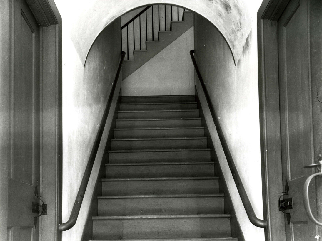 Interior of Meetinghouse, detail of stairway to Ministry’s living quarters, showing doors to brethren’s and sisters’ shoe or cloak rooms on either side (Church Family, Mount Lebanon, New York)