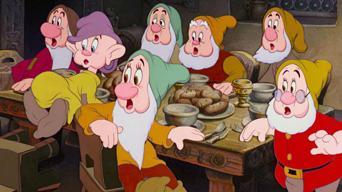 I sette nani si riuniscono intorno alla tavola in attesa della cena nel film animato disney "Biancaneve e i sette nani" (1937)