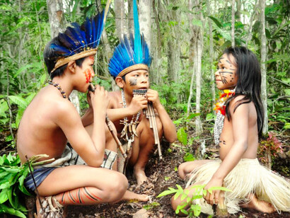Tres niños tocan flautas de pan en su casa en la selva amazónica
