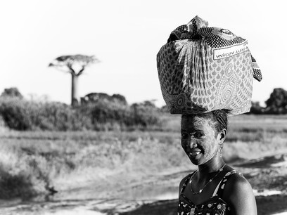 Une jeune femme porte la nourriture sur la tête