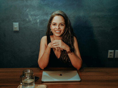 A woman sitting at a table with a laptop, using technology