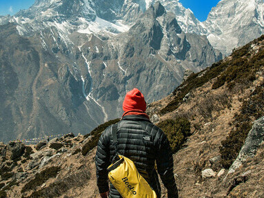 A person standing in front of a mountain in the Himalayas, Nepal