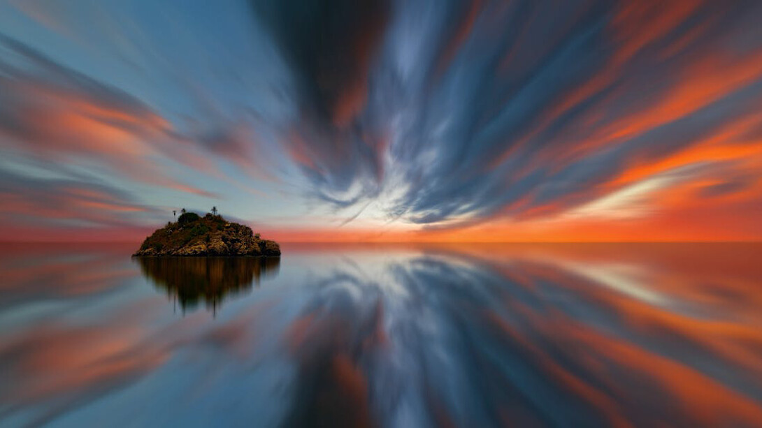 Bathed in the ethereal glow of a sunset, the island stands as a doorway to a timeless realm where light and shadow merge