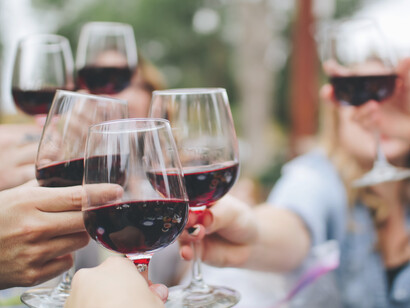Gente brindando con copas de vino. El vino y el agua son hermanos en la dicha de las fiestas y en la comunión de las bodas