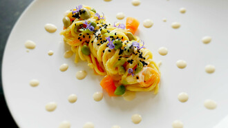 Tagliolini con fave, piselli, sesamo nero e crema di ceci al cumino