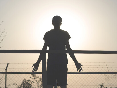 A young boy holds his hands out to the universe as acceptance and confidence. The integration of humanity means having universal self-esteem