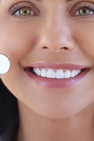 Smiling woman with bright white teeth, highlighting the importance of excellent oral health