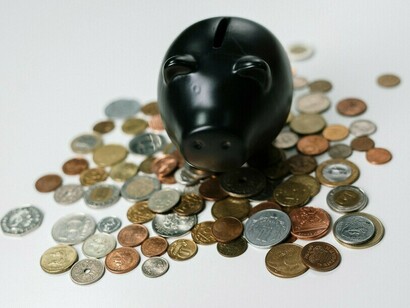 A piggy bank surrounded by scattered coins, reflecting the monetary value tied to nostalgic assets