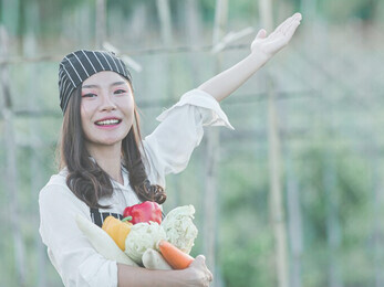 A chef is harvesting fresh produce from an organic farm, exemplifying sustainable agriculture and organic farming practices