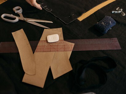 A designer's workspace prepared for cutting fabric, symbolizing the artistry that exists before large-scale production begins