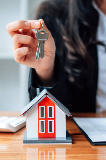 A real estate agent presenting the keys to excited new homeowners, marking the start of their dream home journey