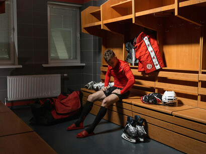 A dedicated athlete in a red long-sleeve shirt and white knee pads, fully focused as he prepares for the demands of competition and high-level performance