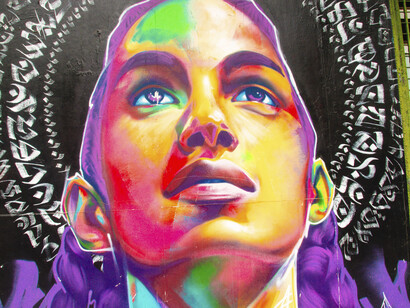 Mural multicolor con el rostro de una mujer obra de Thomas Evans (Denver, EE.UU.) en colaboración con otro artista. Colegiales, Buenos Aires, Argentina