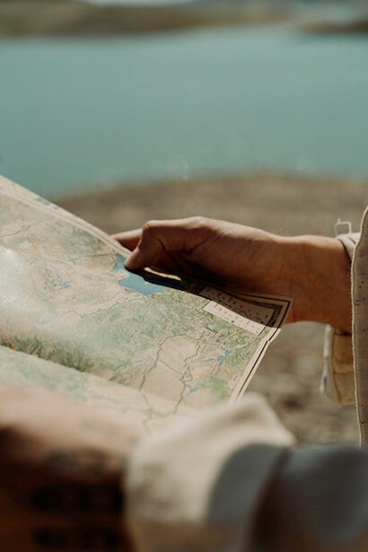 Lost in thought, the man studies the world map, tracing his finger along the lines, as he plans his journey through the global maze