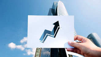 Goals and aspirations are represented on a perforated paper graph in front of a skyscraper, symbolizing the innovation ecosystem that drives economic growth 