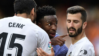 O jogador Vini Jr. em campo fazendo sinal para o juiz da partida