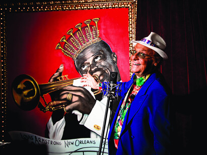 Renzo Arbore fotografato all'interno della sua casa davanti a un quadro di Louis Armstrong
©Athanasios Alexo / STUDIO PRODESIGN