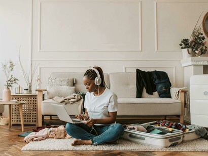 A woman listens to music on her headphones as she packs