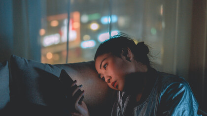 Moça rolando a tela de seu celular infinitamente como um hábito adquirido no cotidiano enclausurado