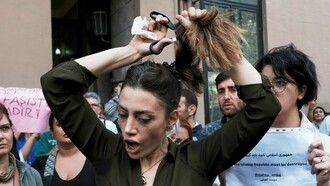 Nasibe Samsaei, iraniana che vive in Turchia, si taglia la coda davanti al consolato iraniano a Istanbul, dopo la morte di Masha Amina a Teheran © Yasin Akgul-AFP