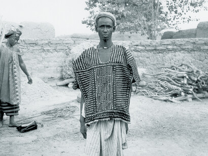 Ill. 63. Central Beledugu hunter wearing a shirt painted with the “Piece of a gourd” (Filen koloni) pattern and trousers painted with the “Bow” (Kala) pattern. Compound of Salimata Kone, Kolokani, 1978.  
Photocredit Sarah C. Brett–Smith
