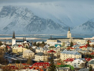 Vista panorâmica da cidade de Reykjavik, na Islândia, revela ruas organizadas, construções acolhedoras e montanhas ao fundo. Um cenário que convida a explorar cada canto da capital islandesa