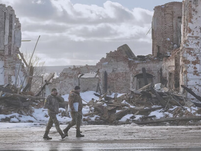 Militares ucranianos caminan junto a un edificio destruido por un ataque ruso en Kupiansk, Ucrania, el 20 de febrero de 2023