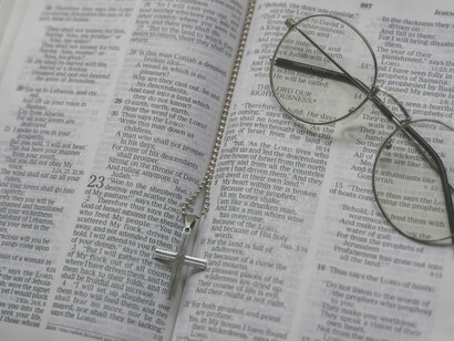 Biblia abierta con un rosario en el medio. La vida de piedad comprende actividades tales como rezar el rosario, ir a misa y hacer oración