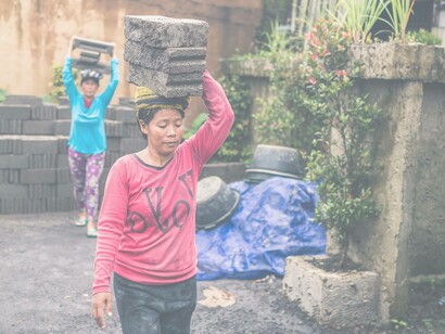 Women carrying bricks on their head