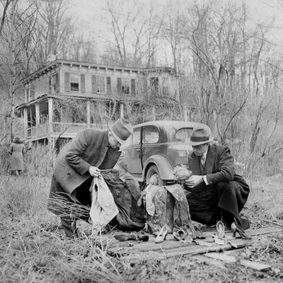 Detectives examinan una peluca de muñeca, zapatos de mujer y un traje y corbatas de hombre encontrados cerca Wisteria Cottage, donde Albert Fish asesinó a Grace Budd