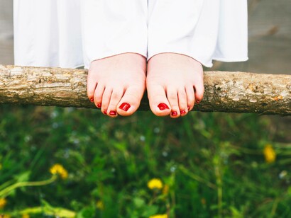 Piedi nudi appoggiati a un tronco: "Cammina scalzo il più possibile: a casa, in giardino o su superfici naturali come sabbia e ghiaia per stimolare i muscoli"