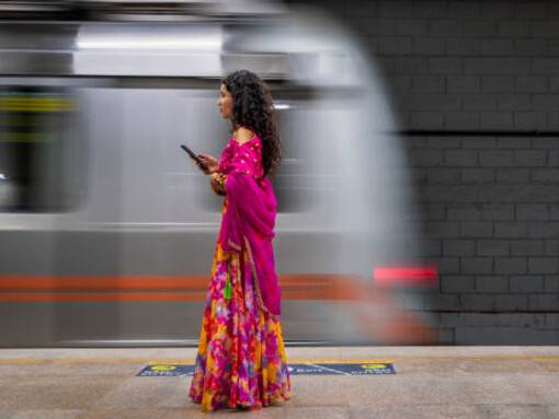A young Indian woman using her mobile phone at a metro station in India