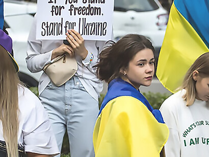 In Germany, a gathering of protesters passionately displays the flags of Ukraine, vehemently opposing the ongoing conflict