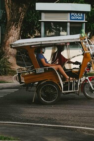 A person travelling in Dumaguete aboard a tricycle, representing the simple realities of provincial urban life