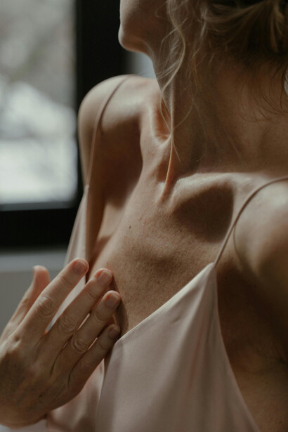 Close-up detail of a woman’s body, showing natural signs of aging