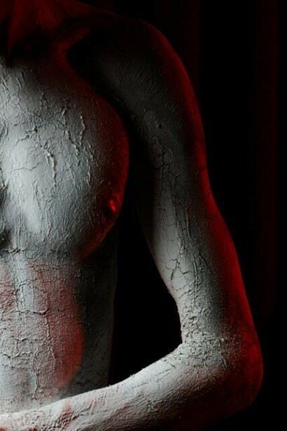 A person covered in white powder, caught in a moment of artistic metamorphosis