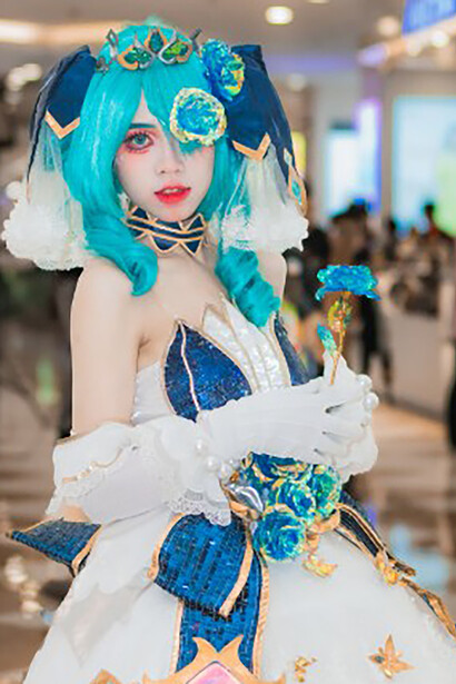 A woman with long blue hair, dressed as an anime character, stood out at the festival with her stunning cosplay