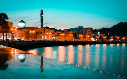 The Mutrah skyline in Muscat, Oman, glows beautifully against the night sky