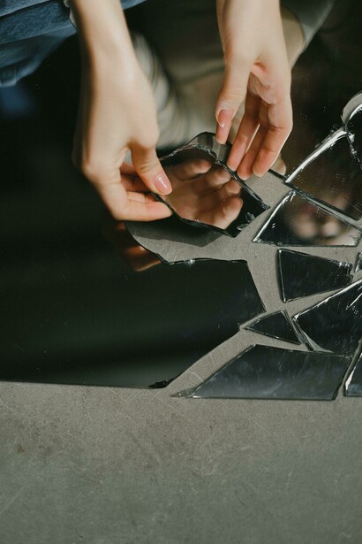 A woman touching a broken mirror 
