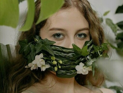 A woman partially silenced by vines and blossoms, reflecting the emotional restraint created by fear of judgment