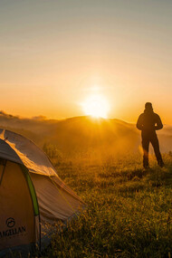 A person camping surrounded by nature, representing the balance many seek between technology and well-being