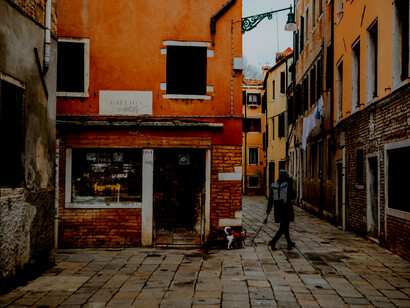 A picturesque Italian street featuring vibrant buildings, floral balconies, and intimate, narrow passageways