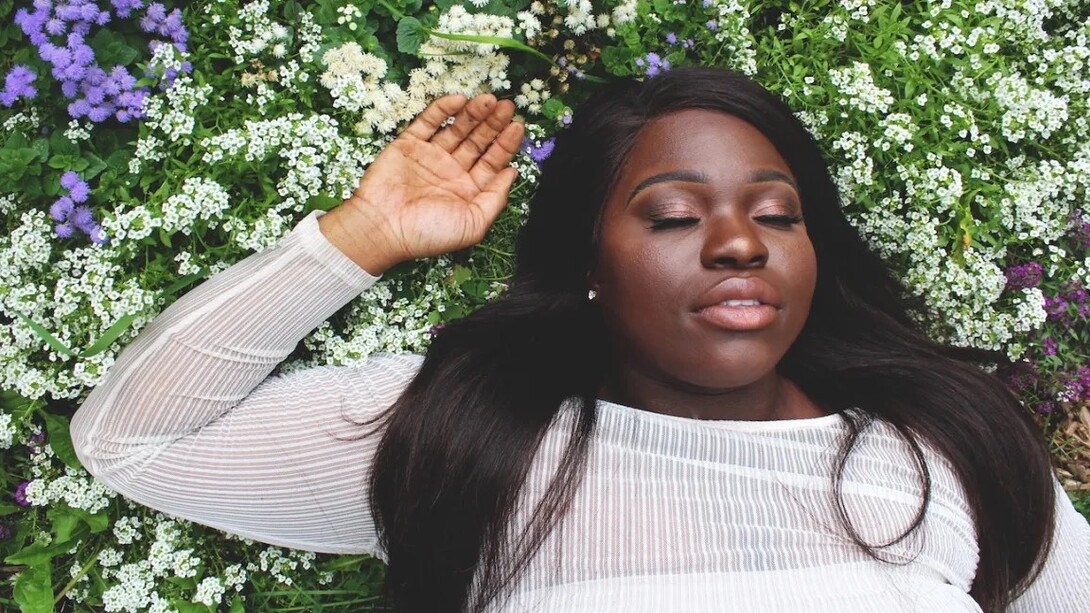 A woman lying on the grass, relaxing, feeling good with herself