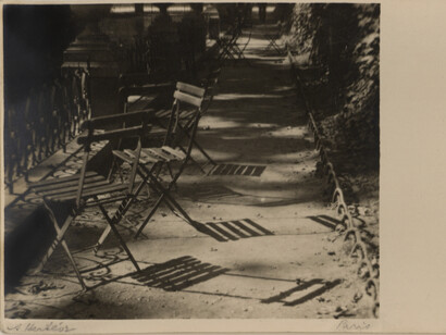 André Kertész (1894-1985), Chairs, The Medici Fountain, Jardin du Luxembourg, 1925, gelatin silver print on carte postale, printed c. 1925, 3 1/8x3 5/8 inches, signed and annotated in margin. Courtesy of Bruce Silverstein Gallery