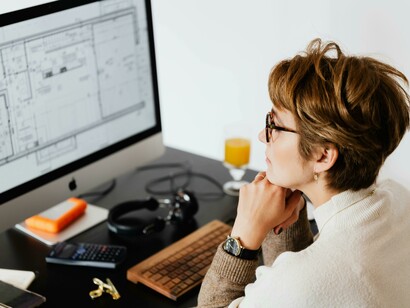 A concentrated female architect working in her office while reflecting on a business project